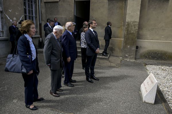 Beate Klarsfeld, Claude Bloch, Serge Klarsfeld et Emmanuel Macron, président de la République française, se recueillent devant l'emplacement de la "baraque aux juifs" pendant la cérémonie d'hommage à Jean Moulin, à la Résistance française et aux victimes de la barbarie nazie au mémorial national de la prison de Montluc à Lyon.