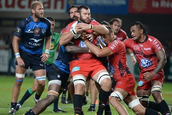 Le joueur de Toulon, Daniel Rossouw (centre) stoppé par le joueur de Montpellier Jim Hamilton, le 16 août lors de la 1ère journée du Top 14