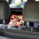 Un bébé installé dans un siège auto d'une voiture.