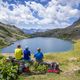 Des randonneurs contemplent un lac de montagne.