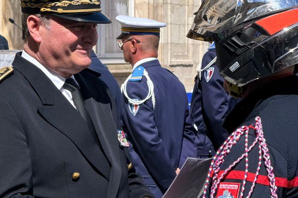 Le préfet d'Arras, Jacques Billant, décore un sépaeur-pompier de la médaille d'or du courage et du dévouement dans la cour de la préfecture d'Arras le 11 juillet 2024.