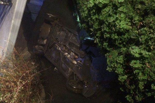 La voiture après une sortie de route finit sa course sur le toit et tombe dans l'eau