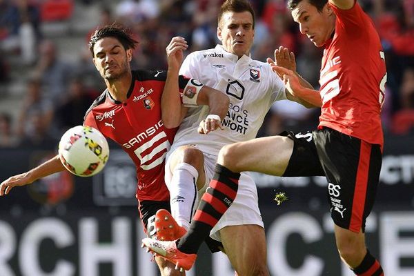 Les joueurs de Rennes Pedro Mendes (à gauche) et Romain Danzé (à droite) opposés au joueur de Caen Ivan Santini (au milieu)