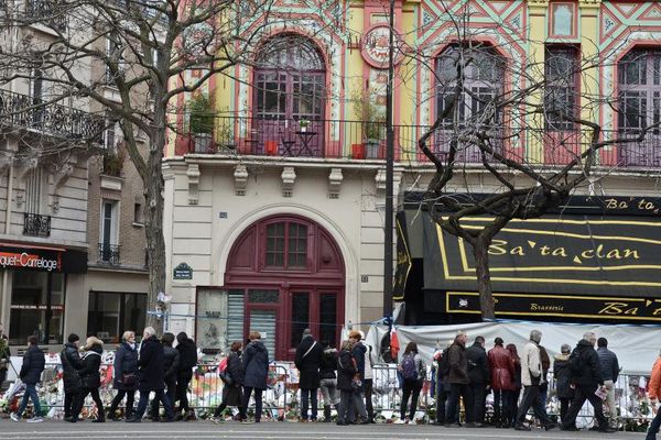 Des personnes se recueillent devant le Bataclan à Paris, le 13 décembre 2015, un mois après les attentats.