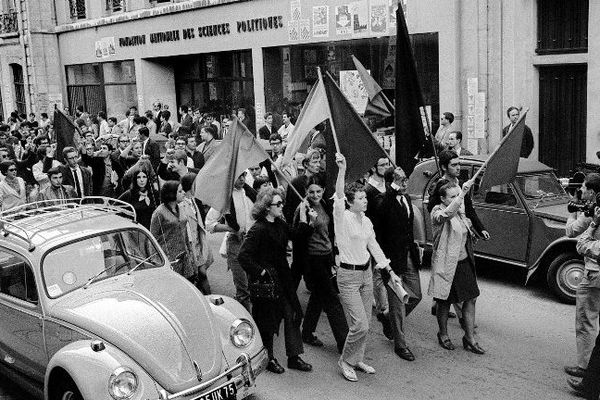 Les étudiants de Sciences-Po défilent dans la rue, drapeaux rouges et noirs en tête, après avoir dû évacuer leur établissement à Paris le 30 juin 1968.
