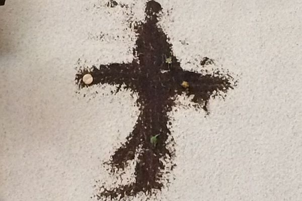 Dessin de croix "torché" sur le mur de l'église Notre-Dame-des-Enfants