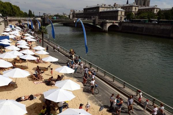 Des passants se promènent sur les quais de Seine, lors du troisième jour de l'opération "Paris plages", le 22 juillet 2015. 