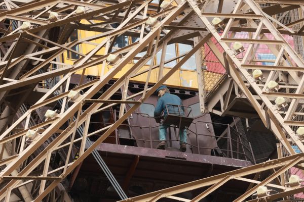 Des mécaniciens travaillant sur les ascenseurs de la Tour Eiffel lors de travaux en 2023.