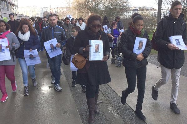 Des participants à la "promenade de soutien" arborent le portrait de Mouhamed