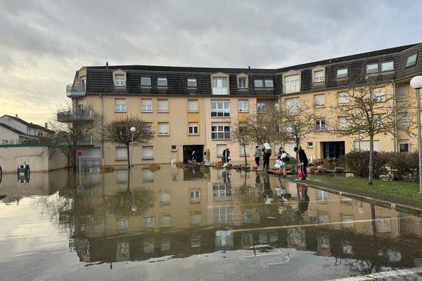 Les habitants de l'immeuble de la rue du général Lassalle à Amnéville évacuent leurs logements inondés.