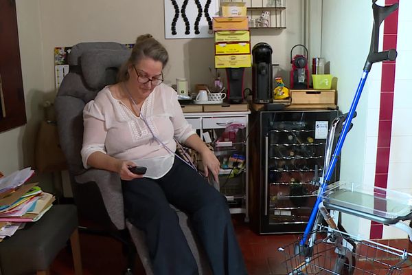 Anabela Neto dans son salon. Cette femme de 54 ans passe du fauteuil roulant au déambulateur, elle ne peut plus marcher normalement, n'a plus de vie de famille et d'emploi. Handicapée à vie depuis la pose d'une bandelette urinaire en 2021, elle ne ménage pas ses efforts pour faire avancer sa cause.