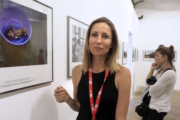 La photographe Véronique de Viguerie devant l'un de ses clichés ramenés du Yémen.