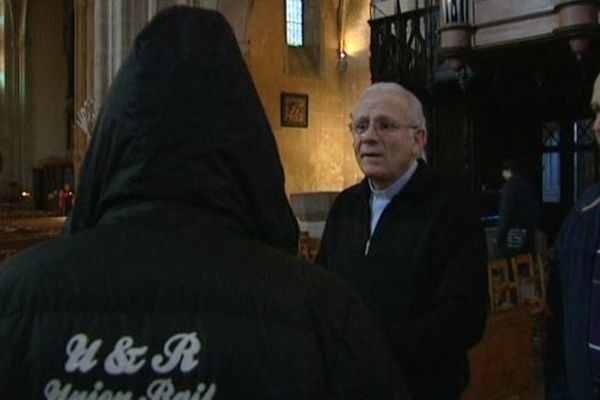 Le père Christian Dequidt reçoit un SDF dans l'église Saint-Michel-des-Lions de Limoges