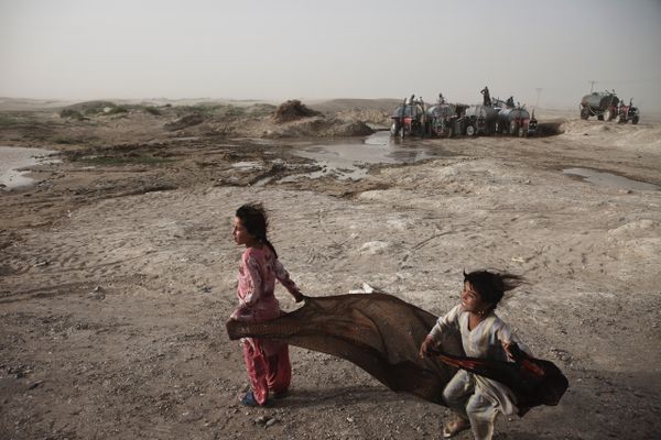 Des petites filles jouent près des tanks à eau à Zaranj, la capitale de la région de Nimruz, frontalière avec l’Iran, au sud-ouest de l’Afghanistan. Dans cette région, il n’y a presque pas de puits d’eau potable et les habitants sont contraints de l’acheter à un prix élevé.