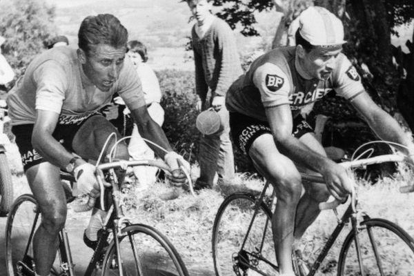 Le Français Jacques Anquetil (à gauche), maillot jaune de leader, est au coude à coude avec son compatriote Raymond Poulidor dans l'ascension du Puy de Dôme, le 12 juillet 1964 lors de la 20ème étape du Tour de France, menant les coureurs de Brive à Clermont-Ferrand. A l'arrivée, Poulidor, 3ème, reprendra 42 secondes à Anquetil, insuffisant cependant pour empêcher le Normand de remporter à Paris son 5ème Tour de France.