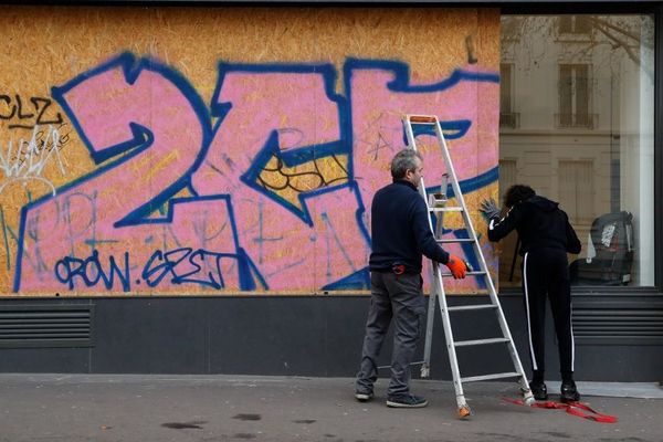 Des commerçants installent des panneaux pour protéger leur établissement avant une manifestation contre la réforme des retraites, le 17 décembre 2019.