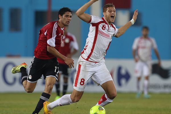 Le joueur tunisien Fakhreddine Ben Youssef, en blanc, devant l'égyptien Mohamed Al Nabi pendant le match de qualification de la Coupe d'Afrique des nations à Tunis, le 19 novembre 2014.