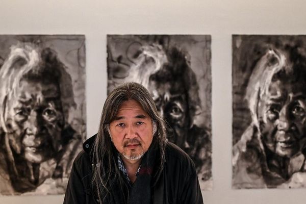 L'artiste chinois Yan Pei-Ming pose devant ses tableaux au musée des Beaux-Arts de Dijon, le 18 avril 2019. 