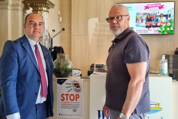 Le maire de Wervicq-Sud (Nord) David Heiremans (à gauche) avec l'un de ses employés municipaux (à droite) devant une affiche de sensibilisation : "stop" aux agressions d’agents et d’élus.