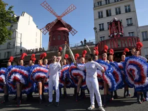 Julien Segui, porteur de la flamme olympique, devant le Moulin Rouge, ce lundi 15 juillet à Paris.