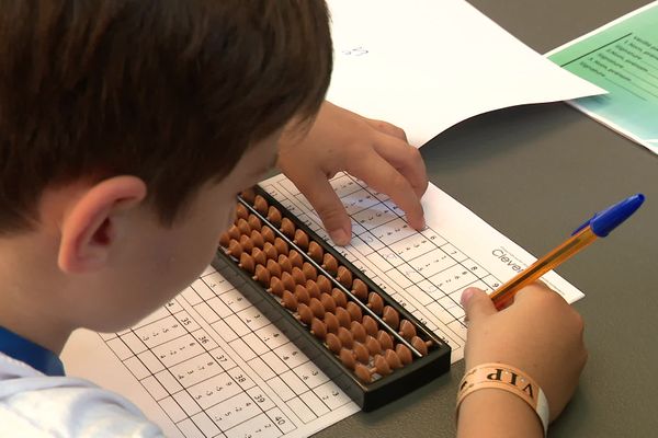 Stylo dans la main droite, boulier posé sur la table, l'attirail parfait pour compter à toute vitesse.