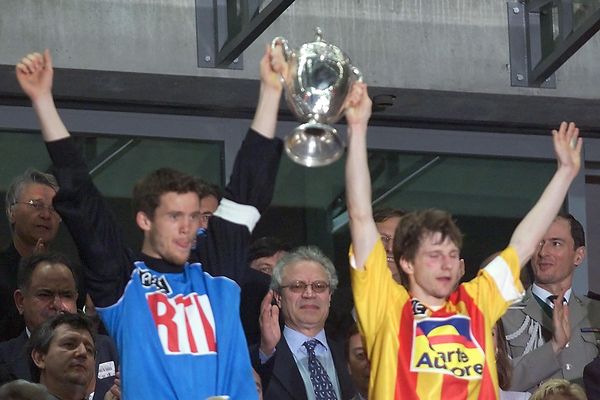 Réginald Becque, le capitaine calaisien, à droite, brandit le trophée avec Mickaël Landreau (FC Nantes). L'union du football pro et du monde amateur.