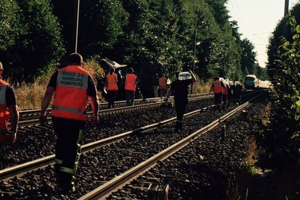 Des personnels de la SNCF amènent de l'eau aux passagers et inspectent les voies, suite à la collision entre une rame et un tracteur.