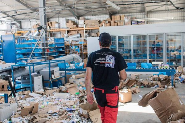 Des pompiers de l'urgence internationale dans un entrepôt pharmaceutique dévasté à Grand Case sur l'île de Saint-Martin le 14 septembre, à la recherche de médicaments