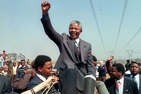 Nelson Mandela, poing levé en 1990 quelques mois après sa sortie de de prison. Le leader de l'ANC a passé 27 ans de sa vie enfermé dans le bagne de Robben Island, réservé aux prisonniers politiques.