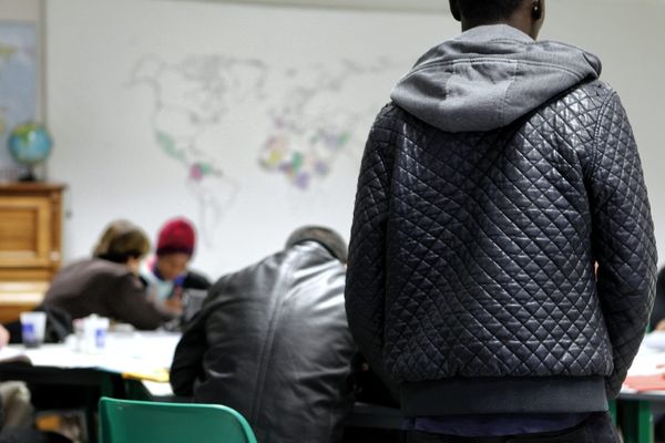 Des mineurs étrangers participent a un cours de français donné par des bénévoles.