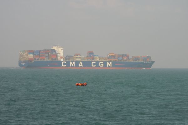 Un "small boat" face à un cargo de transport, en mer du Nord - Photo d'illustration