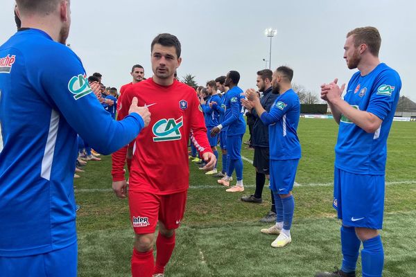 Haie d'honneur pour les joueurs de Guichen (en rouge) à la fin de leur match contre l'Olympique Saumur FC 