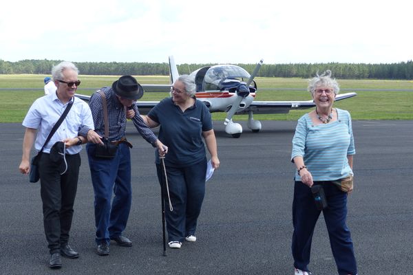 A sa descente d'avion, Charles, ravi, est entouré de ses proches et des membres de l'aéroclub.