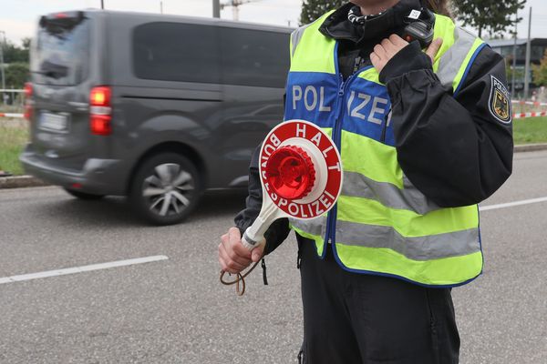 Une policière allemande surveille le trafic automobile au niveau d'un poste frontière entre la France et l'Allemagne.