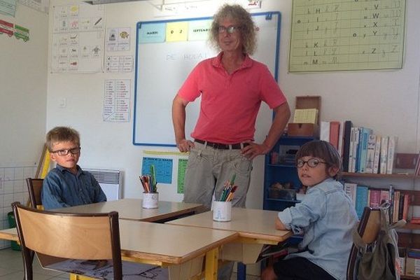 Roland Tournier, le professeur des écoles de Houat, avec ses deux élèves, Martin et Lou