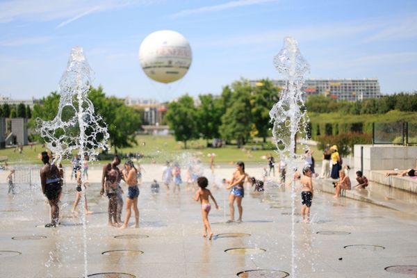 Au parc dans le 15 eme arrondissement, des enfants se rafraichissent dans les fontaines du Parc André Citroën (18 juillet 2023).