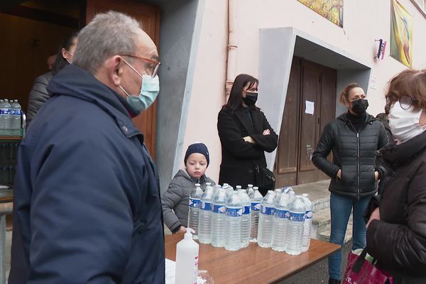 Le maire de Tenay participe à l'organisation des bouteilles d'eau auprès des habitants, devant la salle des fêtes