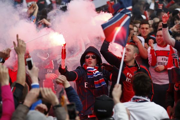 Un supporter brandit un fumigène lors de la remise du trophée de Champion au joueurs du PSG. 