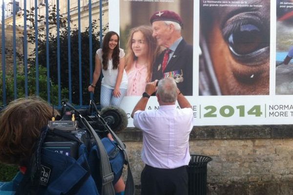 Bethany Newberry pose à côté de l'affiche sur laquelle il figure petite-fille aux côtés de son grand-père vétéran