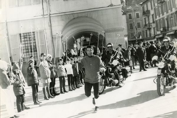 Le départ de la flamme de Saint-Martin-Vésubie, portée par Jean Grinda : les élèves de l'école forment une haie d'honneur avec leurs bâtons de ski.