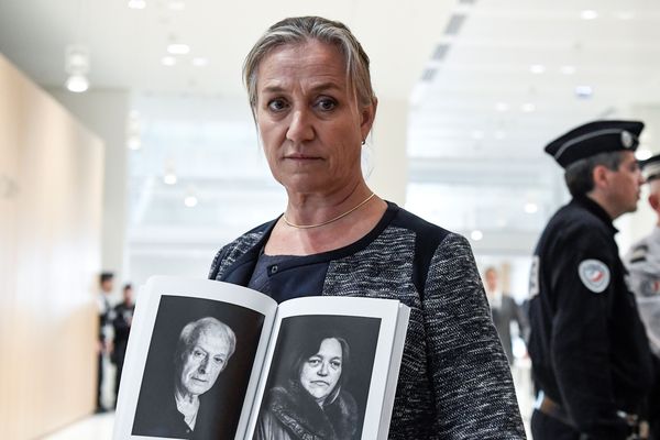 La DR Irène Frachon tenant les portraits de deux victimes du Médiator. 