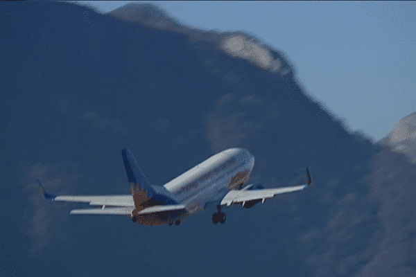 Un avion au décollage depuis Chambéry, entre les massifs de la Dent du Chat et les Bauges.