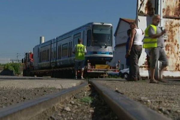 Ces wagons du tramway de Grenoble, arrivés le 5 août aux ateliers de construction du centre, apportent du travail aux salariés...mais pas pour tout le monde.