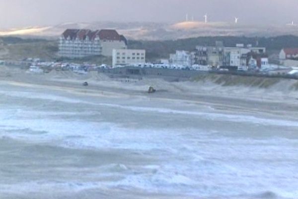 La plage vue d'hélicoptère. Au premier plan, la mer très agitée...