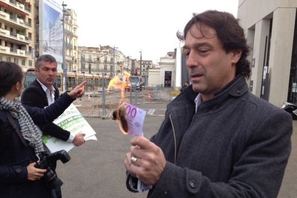 Christophe Cavard, député écologiste du Gard, brûle un billet factice pour dénoncer le projet de la nouvelle gare TGV de la Mogère - 16 mars 2015