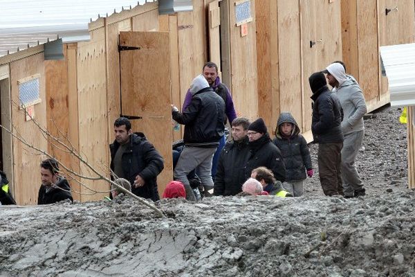 Des migrants accompagnés par des membres d'associations arrivent au camp de Grand-Synthe dans le nord de la France, le 7 mars 2016 