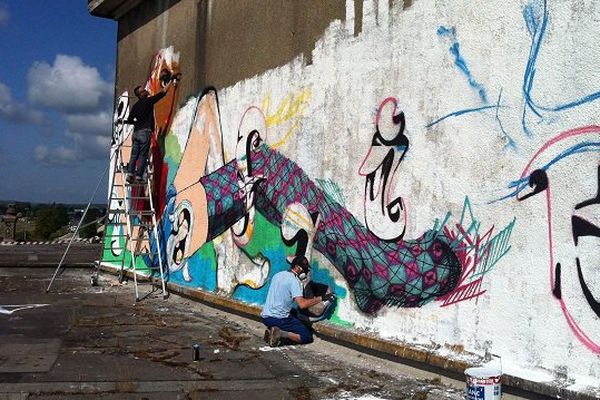 Mr Plume et IncoNito, deux graffeurs tourangeaux, terminent la fresque du silo de Vendôme inaugurée ce vendredi.