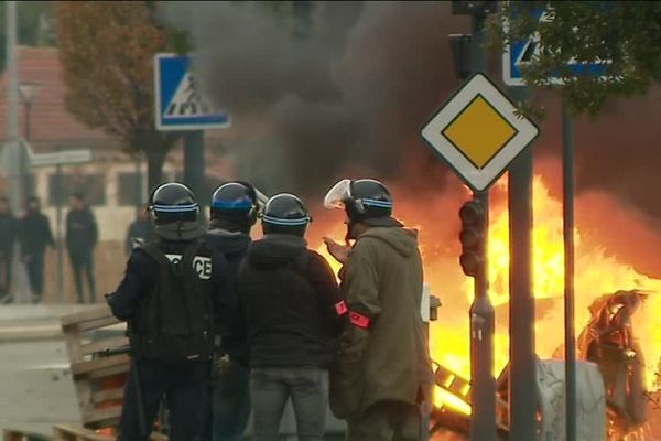 Derrière les policiers, de palettes et des poubelles ont été incendiées.