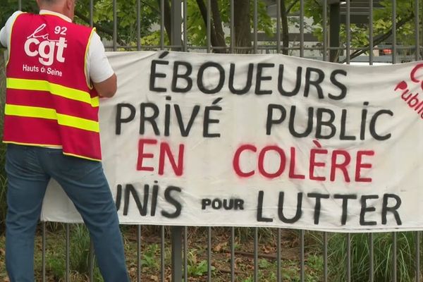 Des sans-papiers manifestent devant un site de traitement des déchets à Paris.