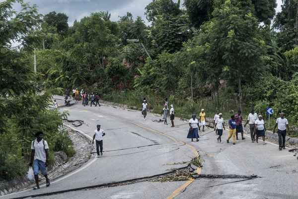 Des badauds sur une route dévastée par le séisme qui a eu lieu samedi 14 août, à côté de Camp-Perrin en Haïti.